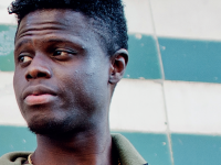 Udsnit af rapportens forside med portræt af ung, mandlig afro-dansker