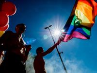 Pride-flag og silhuetter i modlys