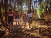 Billede af fire børn og unge, der går gennem skov.