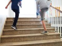 To børn løber op af en trappe