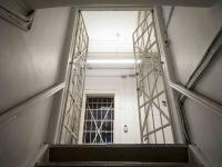 En dør med tremmer i et fængsel set nedefra en trappe