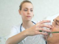sygeplejerske holder iltmaske for patient